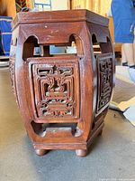 Full view of carved wooden garden stool showing design and structure