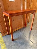 Three-quarter view of rosewood console table