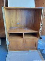 Full view of cabinet showing open TV bay, media shelf, panel doors