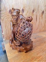 Full view of carved wood figure and birdcage