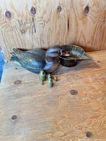 overview of duck decoy, bowl and weights on table
