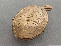 Front view showing engraved floral design and bail