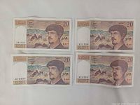Fronts of four 1993 20-franc notes showing Debussy portrait and serials