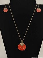 Full view of necklace and earrings set on black display