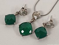 Close-up of earrings and pendant showing stone cut, prong settings and silver mounts