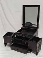 Jewelry box open showing mirror, side compartments, drawers
