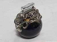 Front view of spherical lighter showing cherub overlay and chrome top