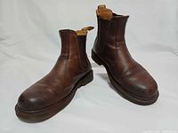 Angled view of both brown leather Chelsea boots