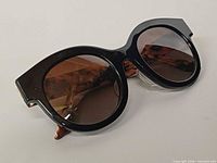 Front view of Emmanuelle Khanh EK 6511 sunglasses showing black panto frame and brown lenses