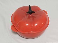 Top angle of red tomato-shaped cocotte with lid