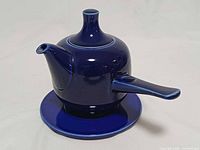 front view of gravy pot on saucer showing spout and handle