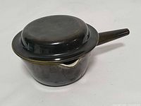 Side view of Royal Copenhagen gravy pot with lid on, showing handle and glaze