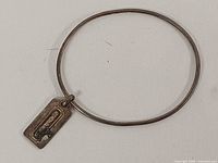 Coach sterling silver bangle bracelet with tag charm front view