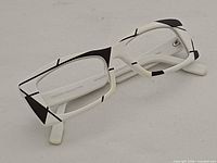 Left three-quarter view of eyeglass frame showing white acetate with black geometric accents