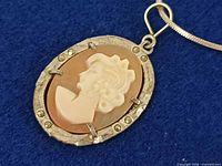Front view of oval cameo pendant showing carved profile and bezel details