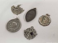 Front view of five pendants showing designs