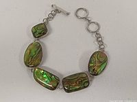 Full bracelet showing five abalone links and toggle clasp