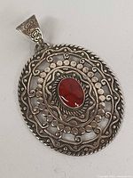 Front view of oval sterling silver pendant with red jasper center