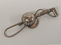 Front view of sterling silver polo mallet and helmet brooch