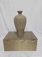 Bottle on patterned box showing overall form and box