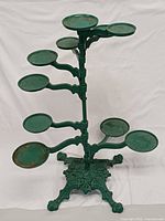 Full view of green cast iron plant stand with nine trays