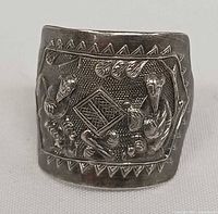 Front view of wide silver ring showing full relief scene and border
