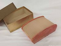 celluloid cigarette box beside original cardboard box, lid removed
