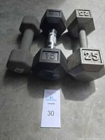 Three hex dumbbells showing weight markings 10, 15, 25 lb