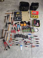 Overall view of all hand tools and bags laid out on floor