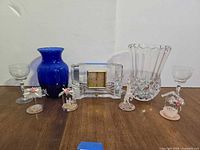 Group shot of all items: clock, two vases, two stem glasses, four figurines
