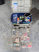 Overall view of blue tote and several clear tackle boxes filled with tackle