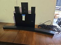 Front view of soundbar, subwoofer, satellite speakers, remote, cables