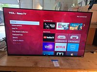 Front view of powered-on TCL Roku TV displaying home screen