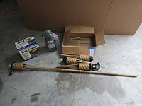 Overview of torches, fuel bottle, two mole trap boxes and open box with poles