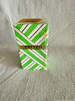 Front view of sealed Carven box showing diagonal stripes and gold logo band