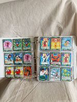 Open binder showing two pages of Dragon Ball Super cards