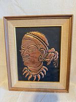Front view of framed copper relief portrait