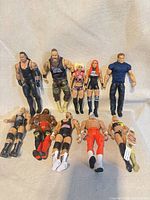 All ten WWE Mattel figures and belt laid out on neutral background