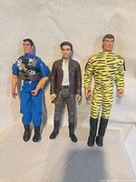 All three figures standing side by side