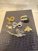 Front view of all six brooches on display board