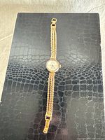 Full view of gold-tone wristwatch showing bracelet and octagonal case