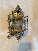 Full view of brass Moroccan style lantern showing cabochons and glass panels
