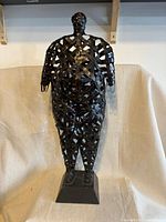 Front view full sculpture showing woven metal human form and base