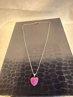 Full view of necklace laid flat showing chain length and pendant