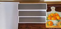 white plastic cutting board, spice rack, decorative wood board visible