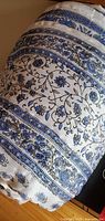 Rolled view showing blue floral pattern on white silk fabric
