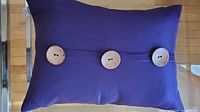 Front view showing purple ribbed fabric and three wooden buttons