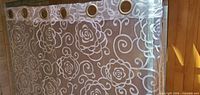 Panel hung showing floral swirl pattern and silver grommets