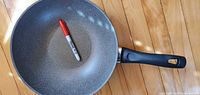 Top view of pan with marker for scale showing grey non-stick interior and handle