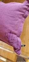 Corner showing RL monogram embroidery on purple herringbone fabric
